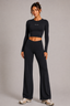 Model wearing midnight navy long-sleeve cropped active top and high-waisted wide-leg pants, full-length side three-quarter view