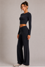 Model wearing midnight navy long-sleeve cropped active top and high-waisted wide-leg pants, full-length front three-quarter view