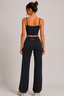 Back view of midnight navy cropped active tank and high-waisted flared pants, full-length view
