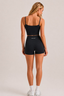 Back three-quarter view of model wearing midnight navy cropped active tank and high-waisted fitted active shorts