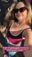 Stride Crop in Crimson, customer selfie of smiling woman in sunglasses wearing the crop with jeans. Caption reads: Bought this @princexmott activewear top at the markets. It looked so cute I wore it home!!! We love a small biz