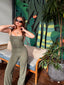 Daily Crop in Field Green, lifestyle photo of model in sunglasses wearing the cami crop with matching wide leg pants in front of a tropical mural