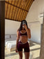 Stride Shorts in Crimson, mirror selfie of model in a bedroom with a thatched ceiling, styled with a matching Stride Sports Bra