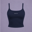 A navy blue crop top with thin straps and a scoop neckline, featuring the white text 'PRINCE X MOTT' printed on the chest, displayed against a solid lavender background.